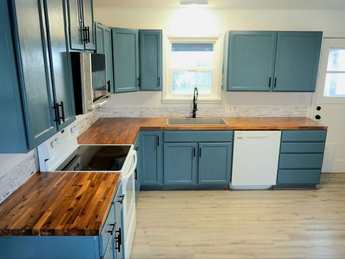 Kitchen after remodel — new blue cabinets and butcher block counters
